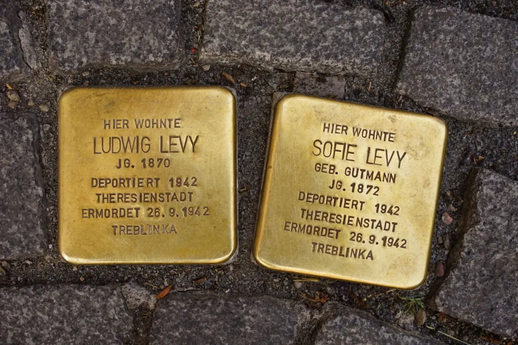 Bild von zwei Stolpersteinen, Metallwürfel aus Messing mit Inschrift, umgeben von Granitpflaster